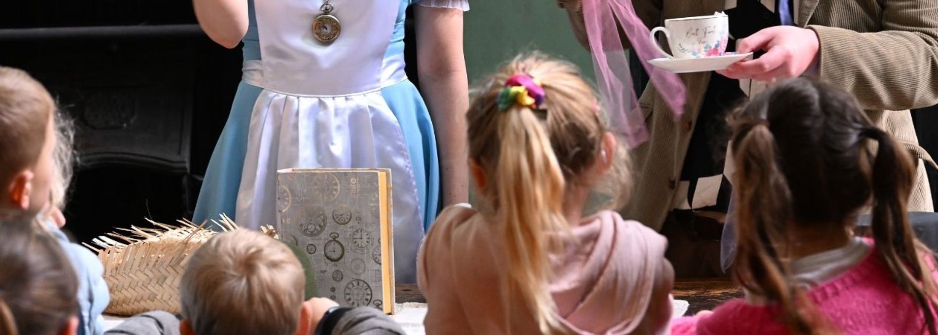 Rhes o blant o'r tu ôl sy'n gwylio golygfa gyda dau actor